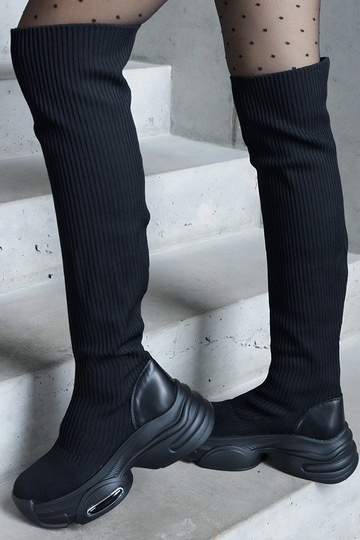 Juodi slip-on ilgi batai su lanksčia šonine dalimi ant masyvios pado Lokira