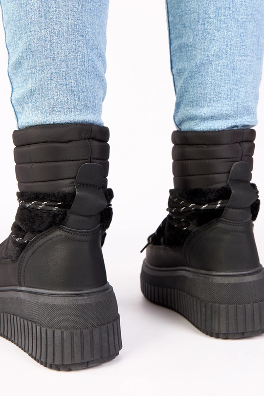 Juodi sniego batai ant platformos su...