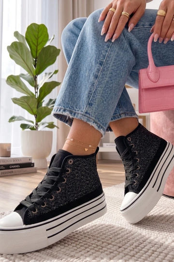 Juodi sportbačiai virš...